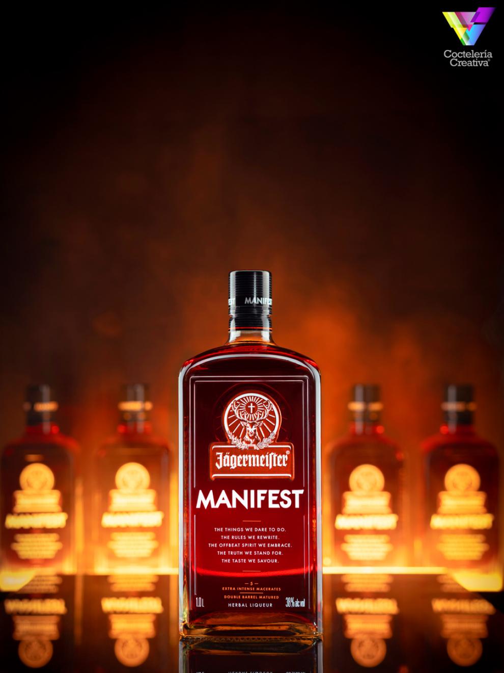 Botella de Jägermeister Manifest con fondo oscuro con botellas Botella de Jägermeister Manifest con fondo oscuro con botellas