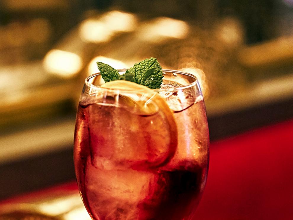 Imagen de cocktail con hielo, rodaja de limón y menta